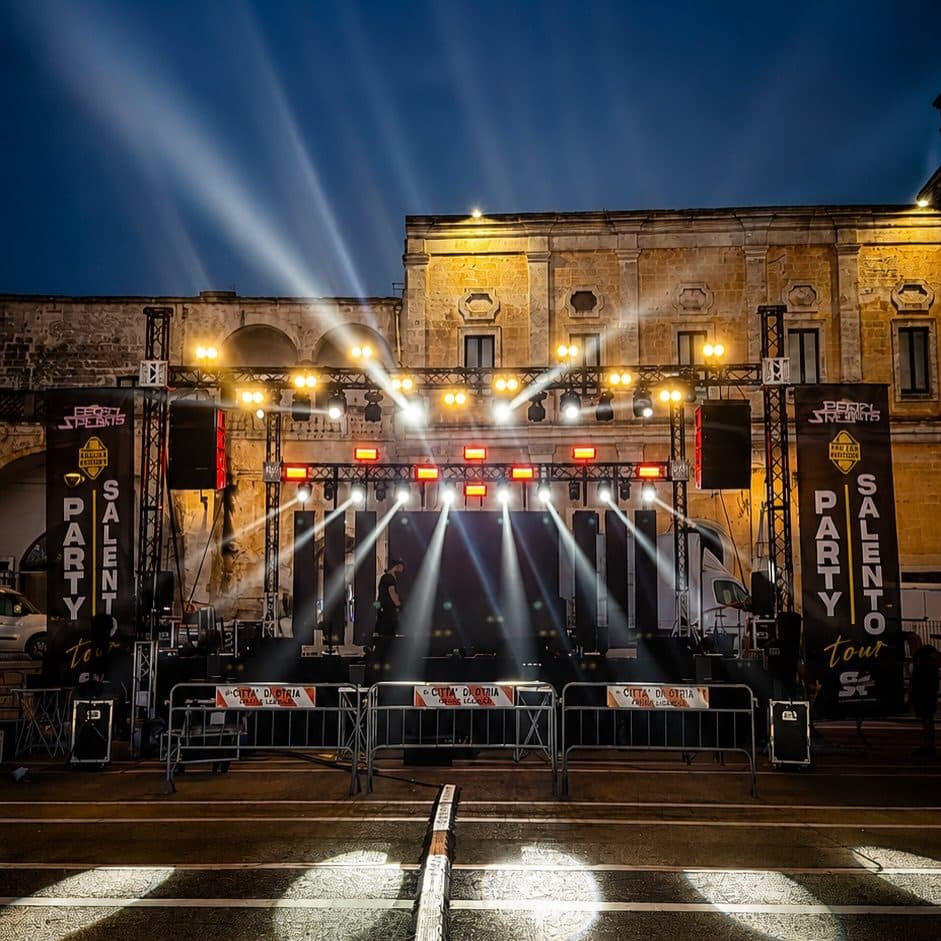 Palco illuminato di notte davanti a un palazzo storico