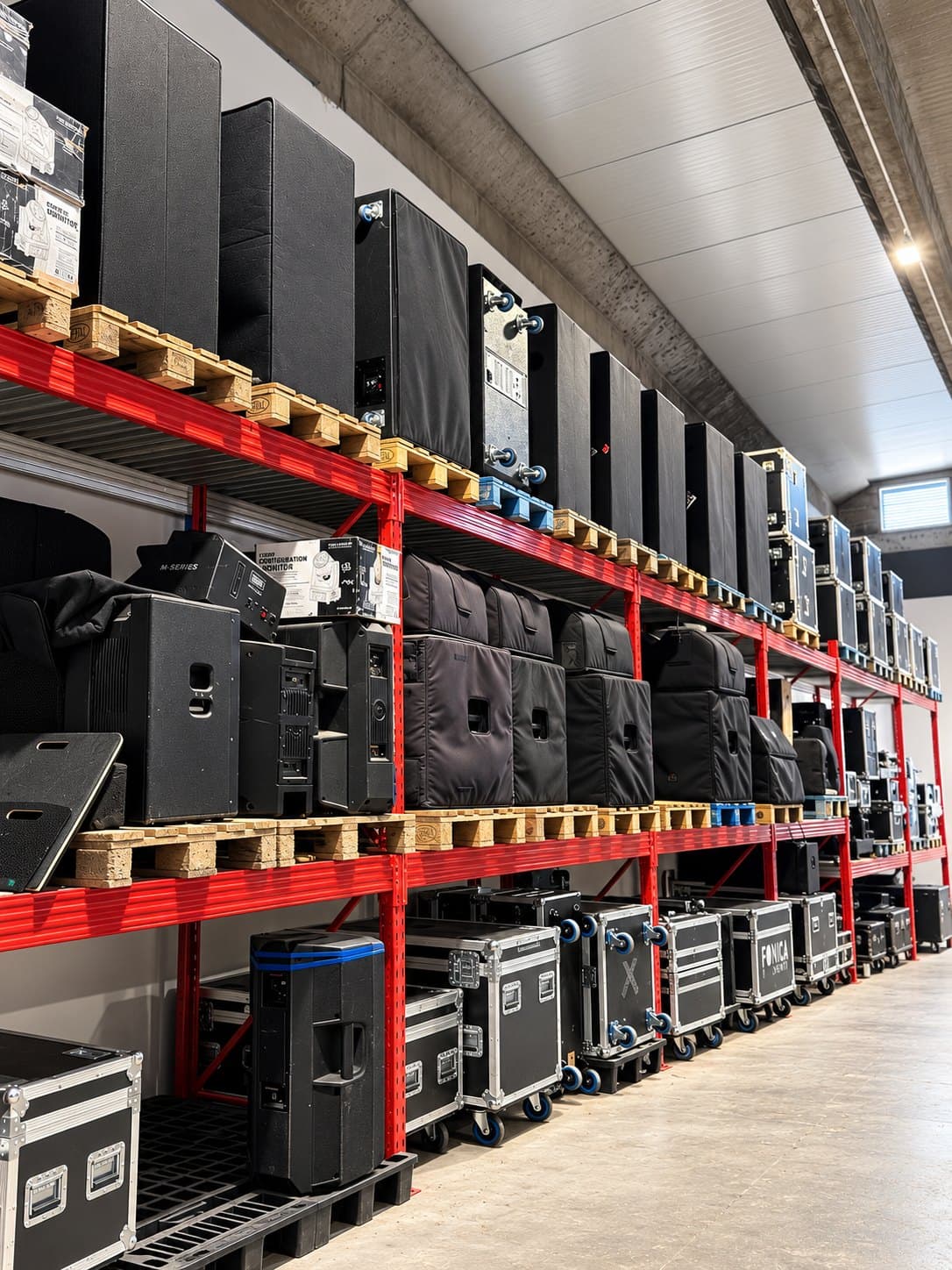 Scaffalature con casse, subwoofer e flight case incolonnati